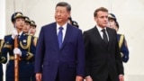 Chinese leader Xi Jinping stands next to French President Emmanuel Macron during a welcome ceremony in Beijing on December 4.